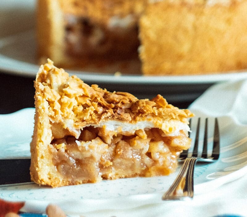 A slice of apple pie on a plate and a fork