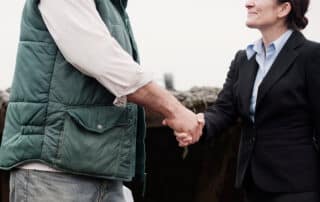 Farmer shaking hands with a suited woman