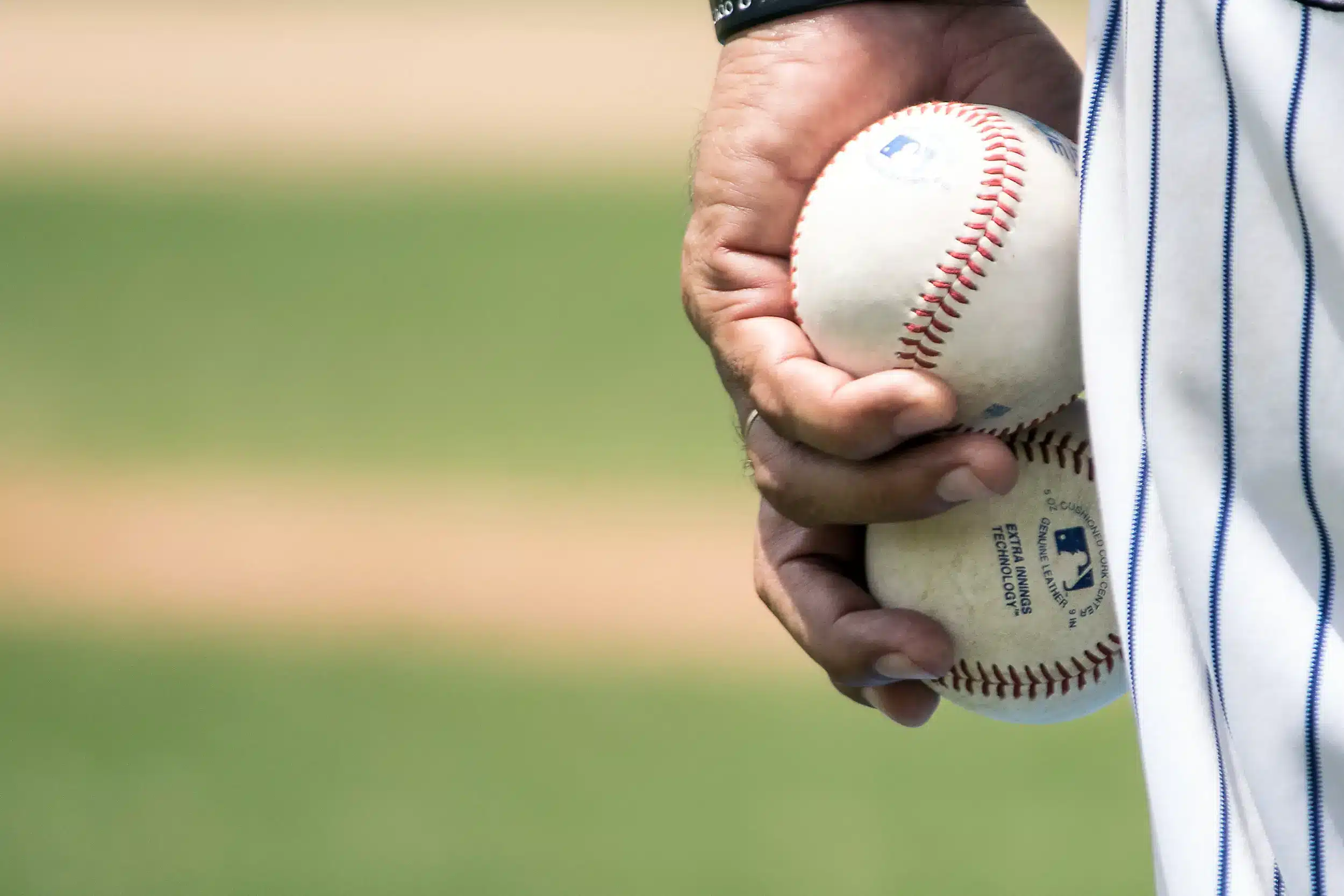 Baseball pitcher holding two baseballs in one hand