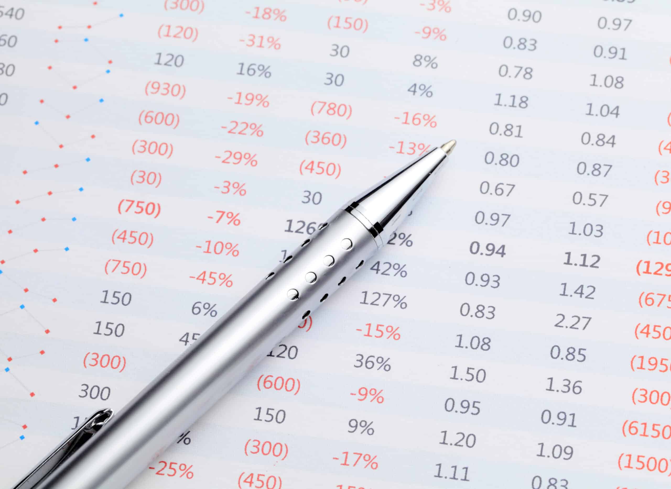 Numbers on a spreadsheet with a pen in foreground