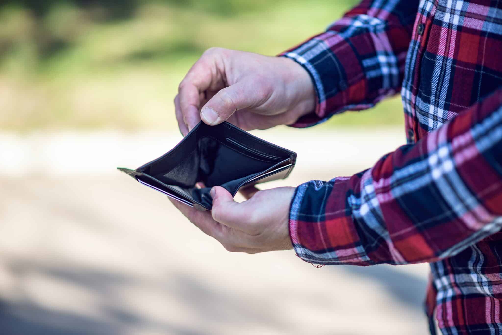 Man opening empty wallet