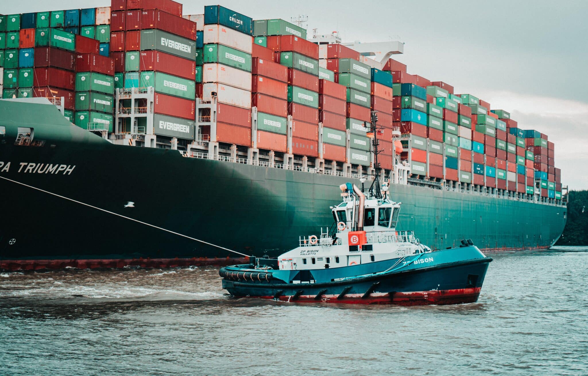 tugboat leading big container ship