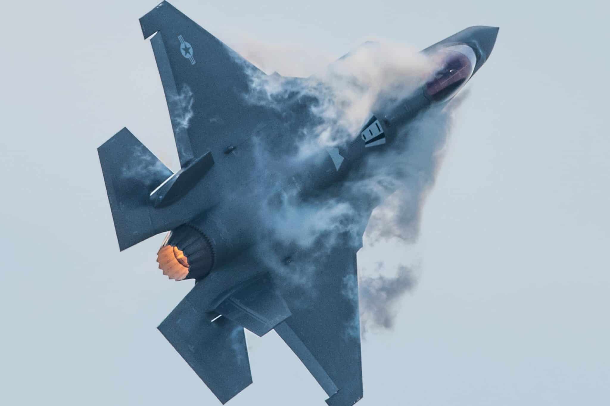 A cloud of smoke seemingly emerges from F-35 aircraft mid air as it executes a tight turn.