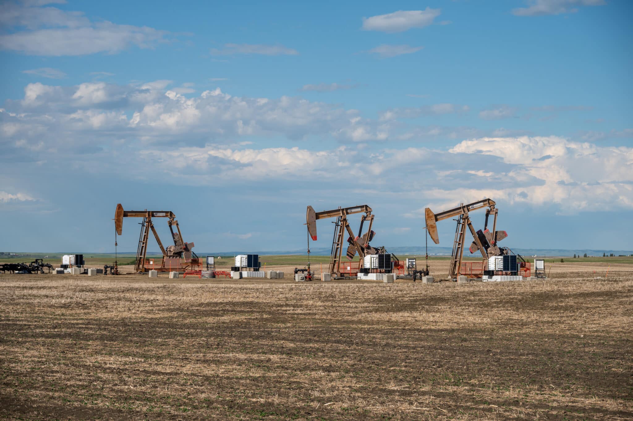 Three pumpjacks in an oil field