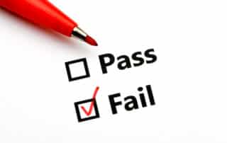Pass or fail checkboxes printed on white paper with black in. The Fail box is ticked with red pen