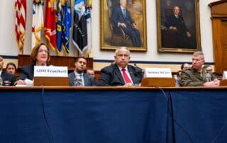 5 military officials sit at a table as they provide testimony