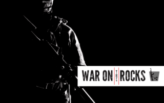 Silhouette of a soldier in darkness in the background with the War on the Rocks logo in the foreground