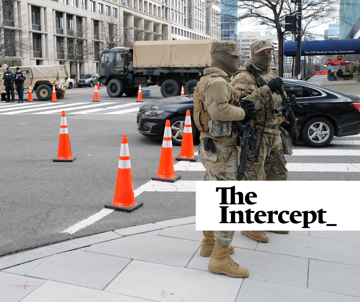 Two National Guardsmen supervise a DC checkpoint as a sedan is cleared to pass