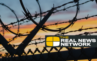 chain link fence with coilerd barbed wire at the top.
