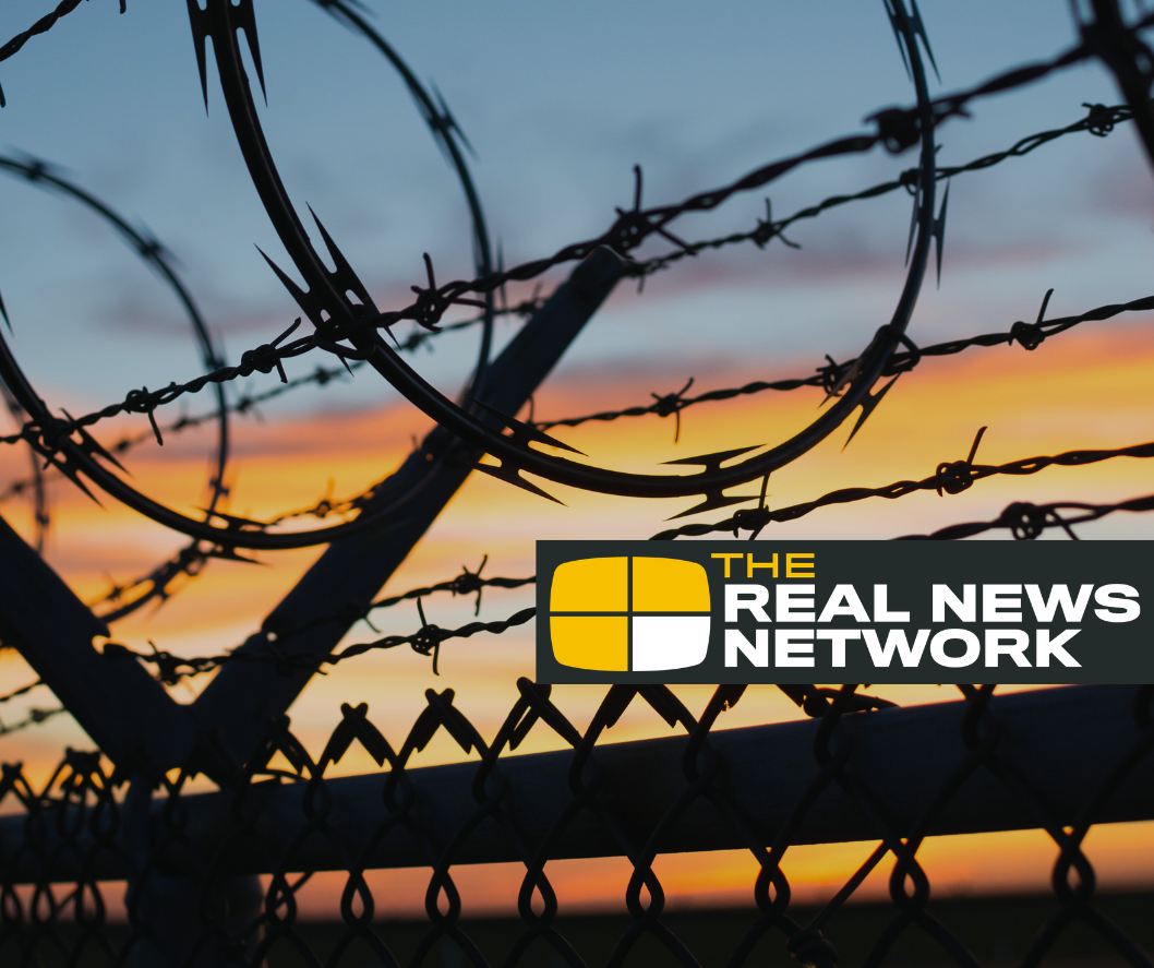 chain link fence with coilerd barbed wire at the top.