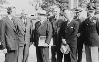 Black and white photograph of President Truman with his some of his top advisers, upon his return to Washington from the Wake Island