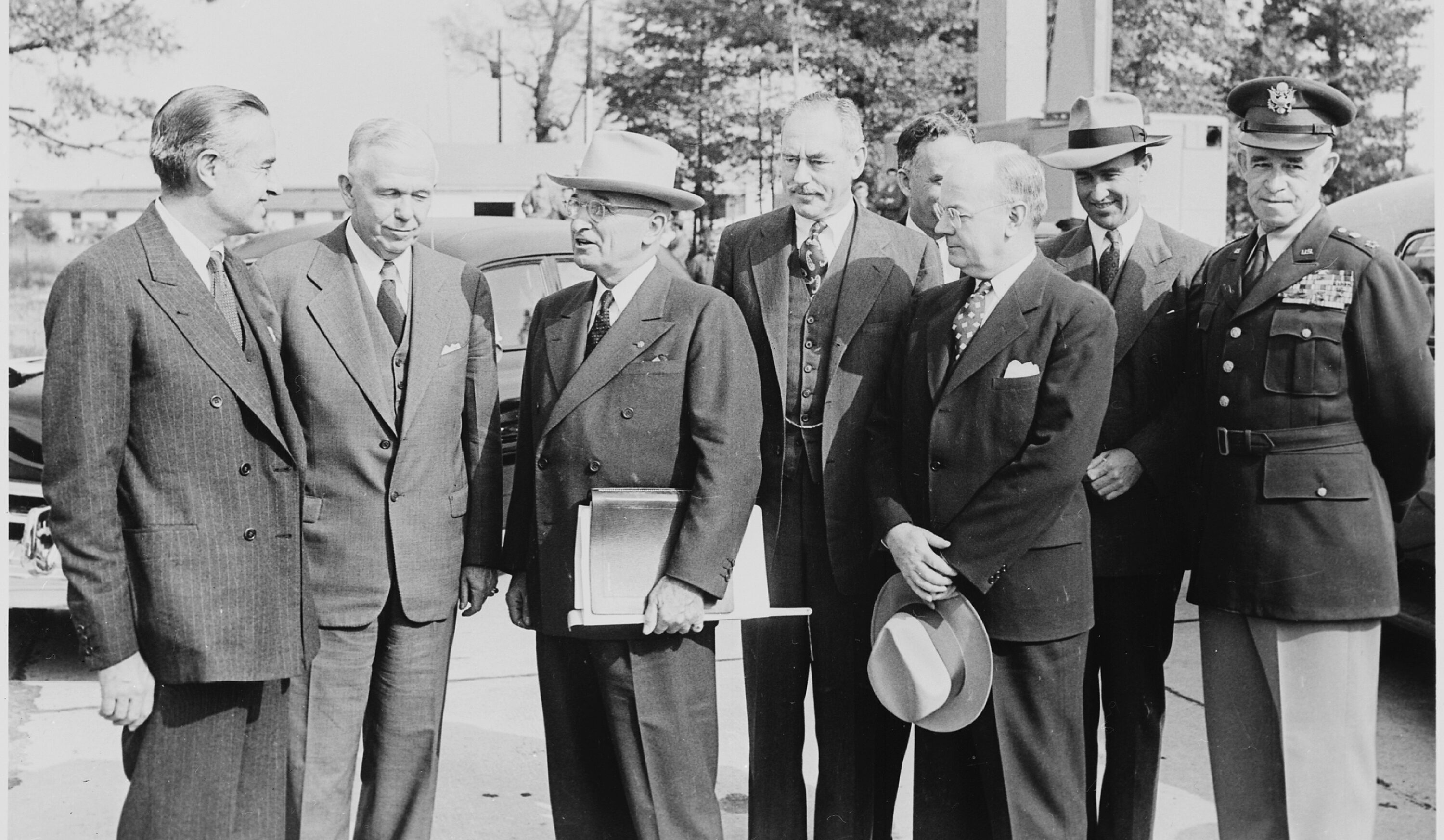 Black and white photograph of President Truman with his some of his top advisers, upon his return to Washington from the Wake Island